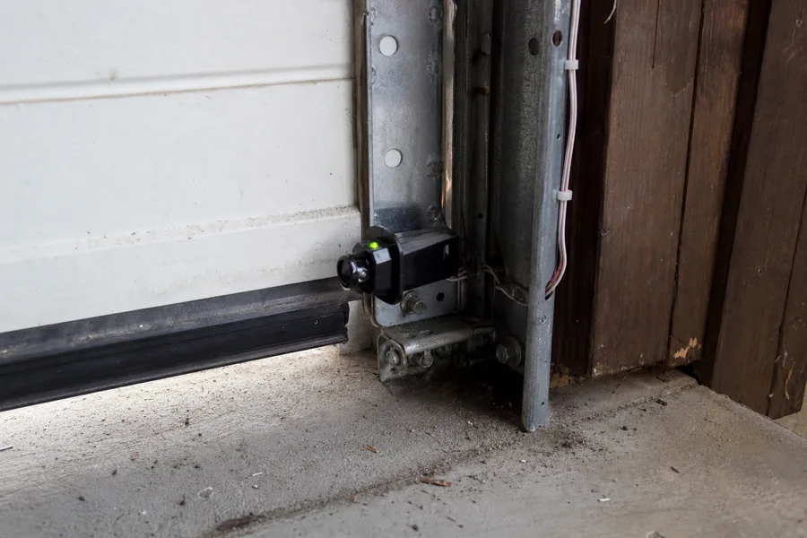 Photo-eye safety sensor at the base of a garage door track in Atlanta, GA